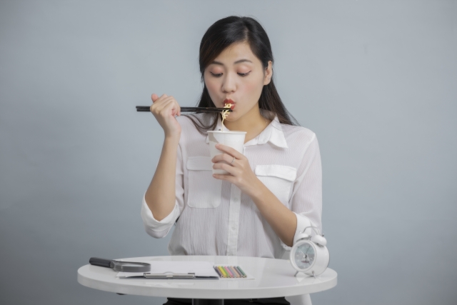 ウォーターサーバーで作ったカップラーメンを食べる女性